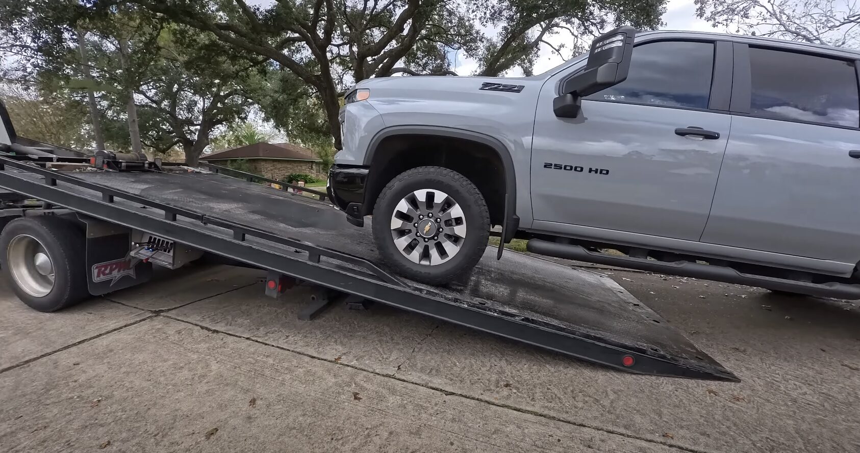 Professional flatbed towing truck transporting vehicle safely